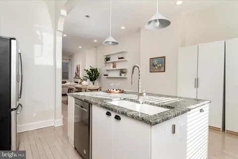 a kitchen with a sink a refrigerator and wooden floor