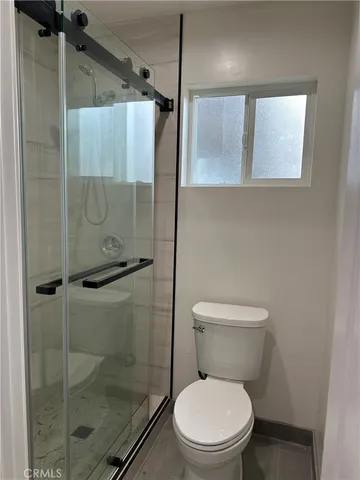 a white toilet sitting next to a shower