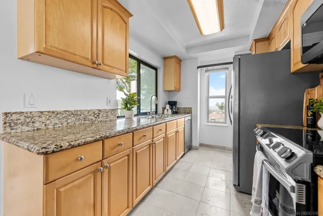 a kitchen with granite countertop a sink stove and cabinets