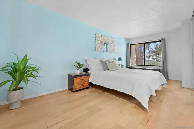a bedroom with a large bed and a potted plant
