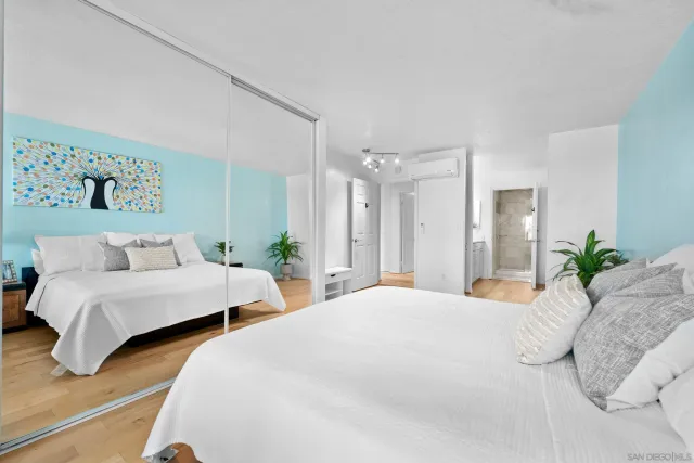 a bedroom with two beds and potted plant