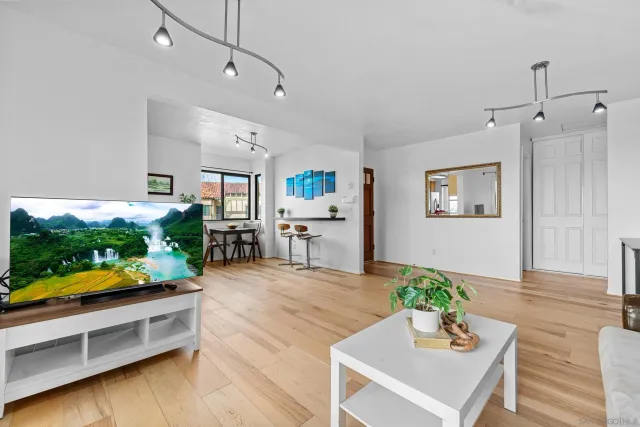 an open kitchen with wooden floor and potted plant