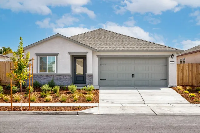 a front view of a house with a garden