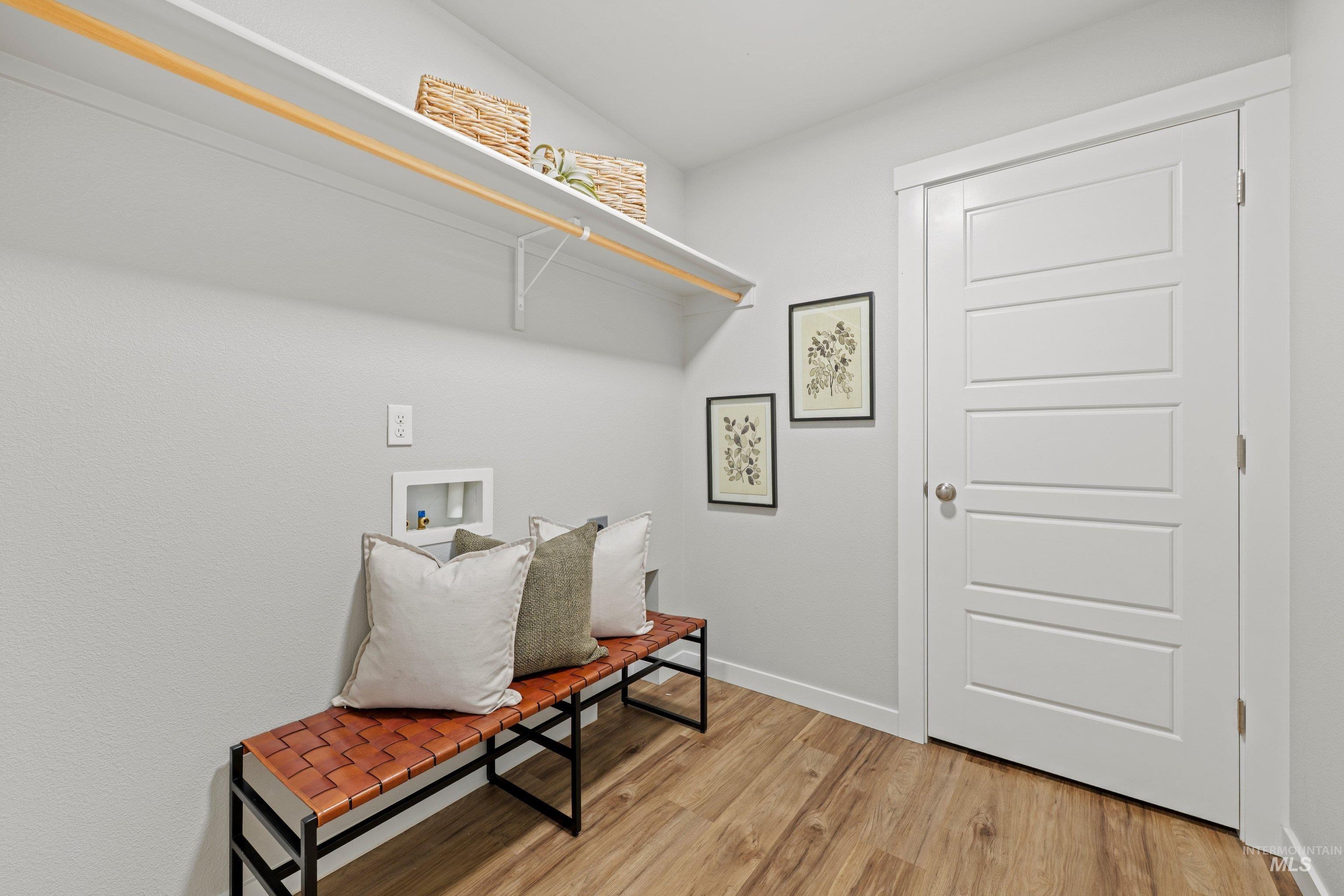 12744 West Fig Street Boise, ID 83713 - Photo 20 of 34 Dedicated laundry space featuring a white shelf with hanging rod, wood-finish flooring, and light gray wall paint