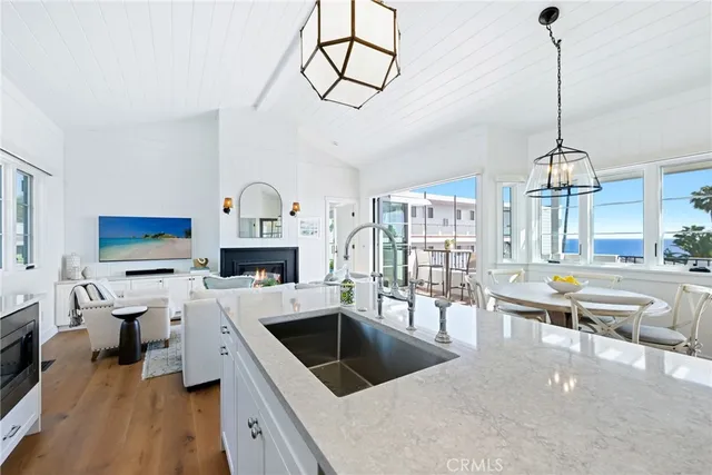 a large kitchen with a stove a sink dishwasher a fireplace with wooden floor