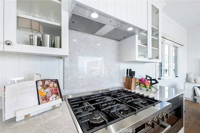 a room with furniture a stove and cabinets