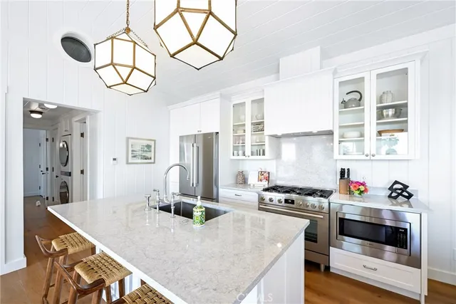 a kitchen with stainless steel appliances granite countertop a stove a refrigerator a oven a sink with island and chairs