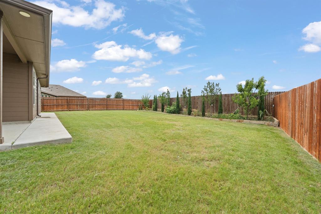 4600 Fringetree Way Crowley, TX 76036 - Photo 32 of 40 Spacious backyard featuring a large green lawn, a concrete patio, and a wood privacy fence