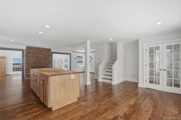 an open kitchen with a sink and wooden floor