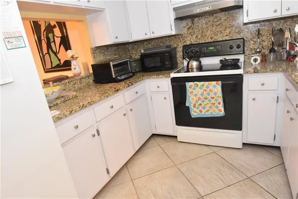 a kitchen with stainless steel appliances granite countertop a stove a microwave and a refrigerator