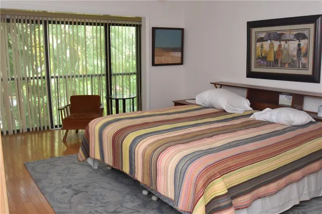 a bedroom with a bed and glass door