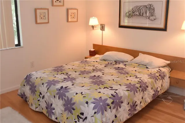 a bedroom with a bed and painting on the wall