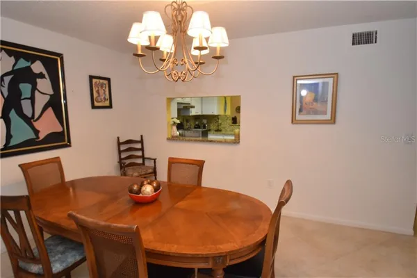 a view of a dining room with furniture a chandelier and wooden floor