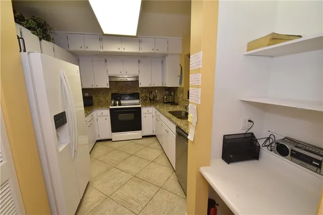 a kitchen with a sink a refrigerator and cabinets