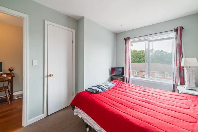 a bedroom with a bed and a large window