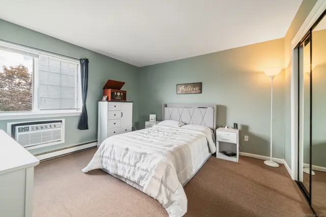 a bedroom with a bed and a large window