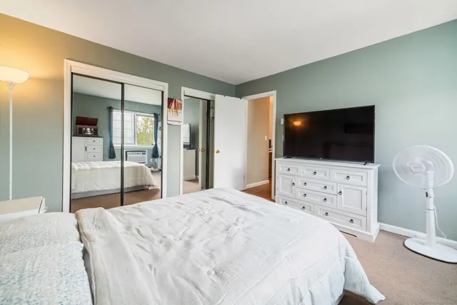 a bedroom with a flat screen tv and a bed