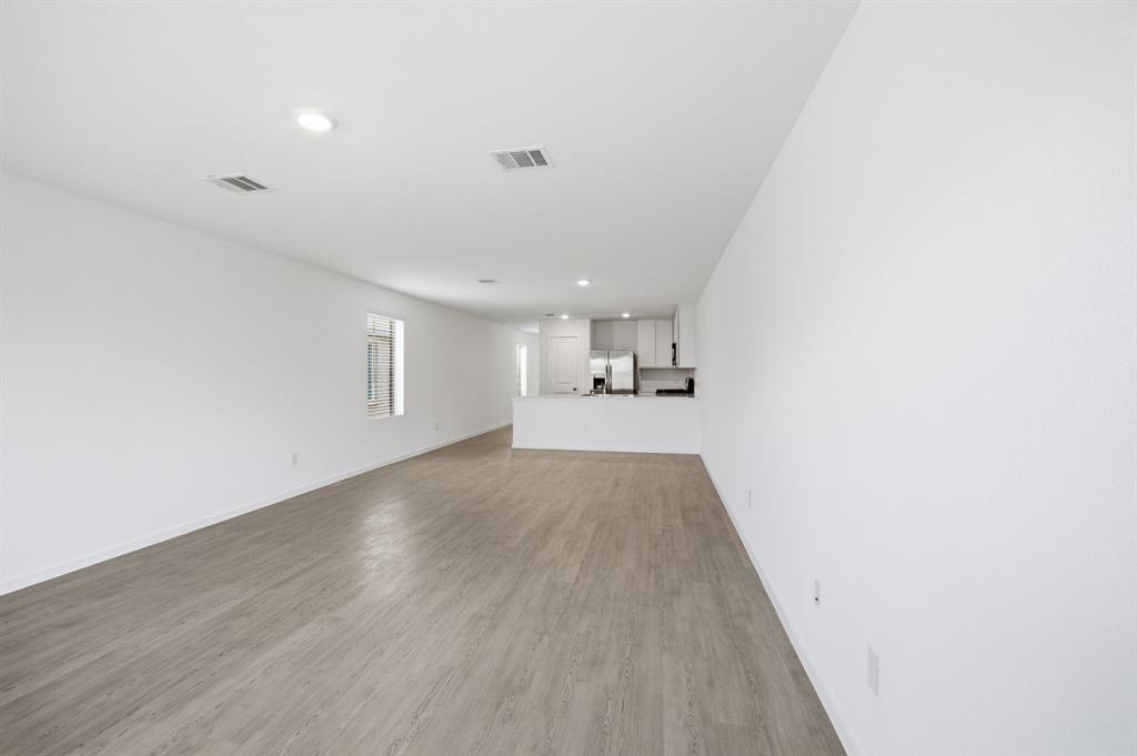 2128 Doc Holliday Road Joshua, TX 76058 - Photo 17 of 28 Open-concept living area featuring wood-finish flooring, recessed lighting, and a window providing natural illumination