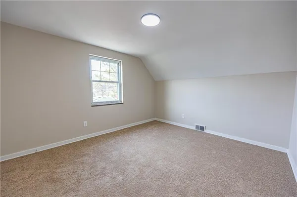 an empty room with a window and a ceiling fan