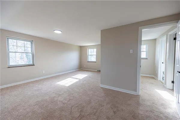 an empty room with windows and closet