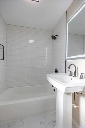 a bathroom with a bathtub a sink a toilet and a mirror