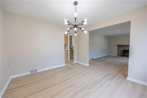 a view of an empty room with a chandelier fan