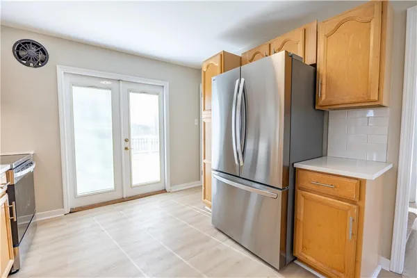 a metallic refrigerator freezer sitting in a kitchen