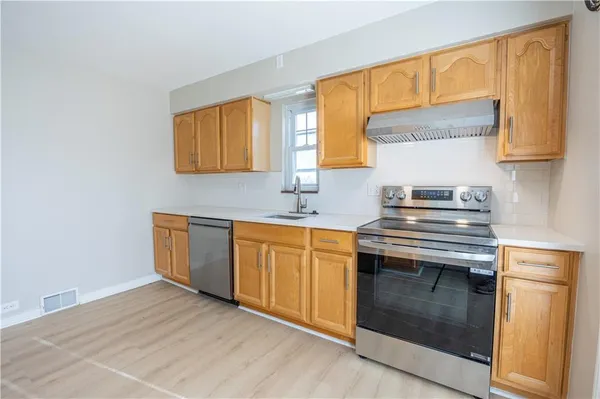 a kitchen with stainless steel appliances granite countertop a sink a stove and a refrigerator
