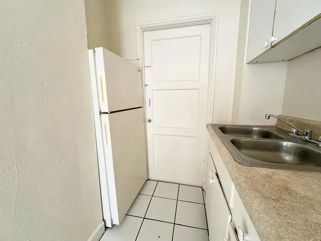 a kitchen with a refrigerator and a sink