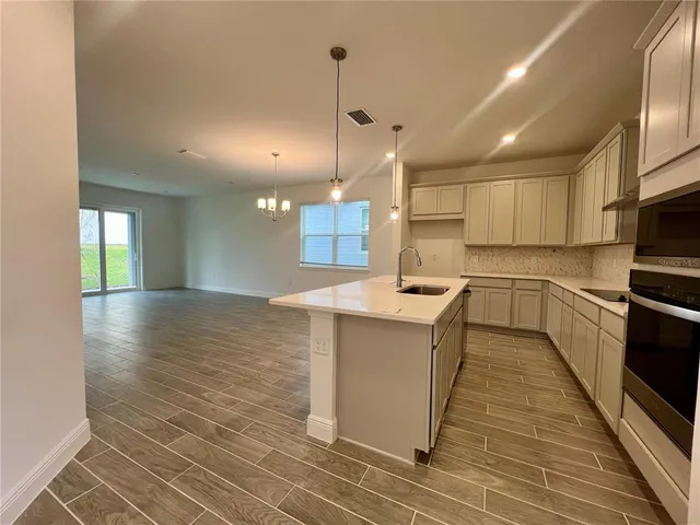 a kitchen with stainless steel appliances granite countertop a sink a stove and a refrigerator