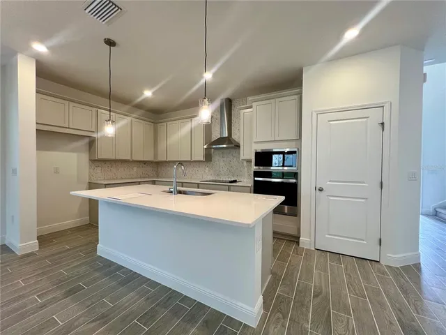 a large kitchen with stainless steel appliances granite countertop a lot of counter space and a refrigerator