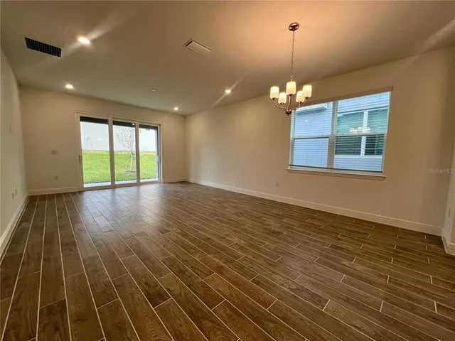 a view of a room with wooden floor and chandelier