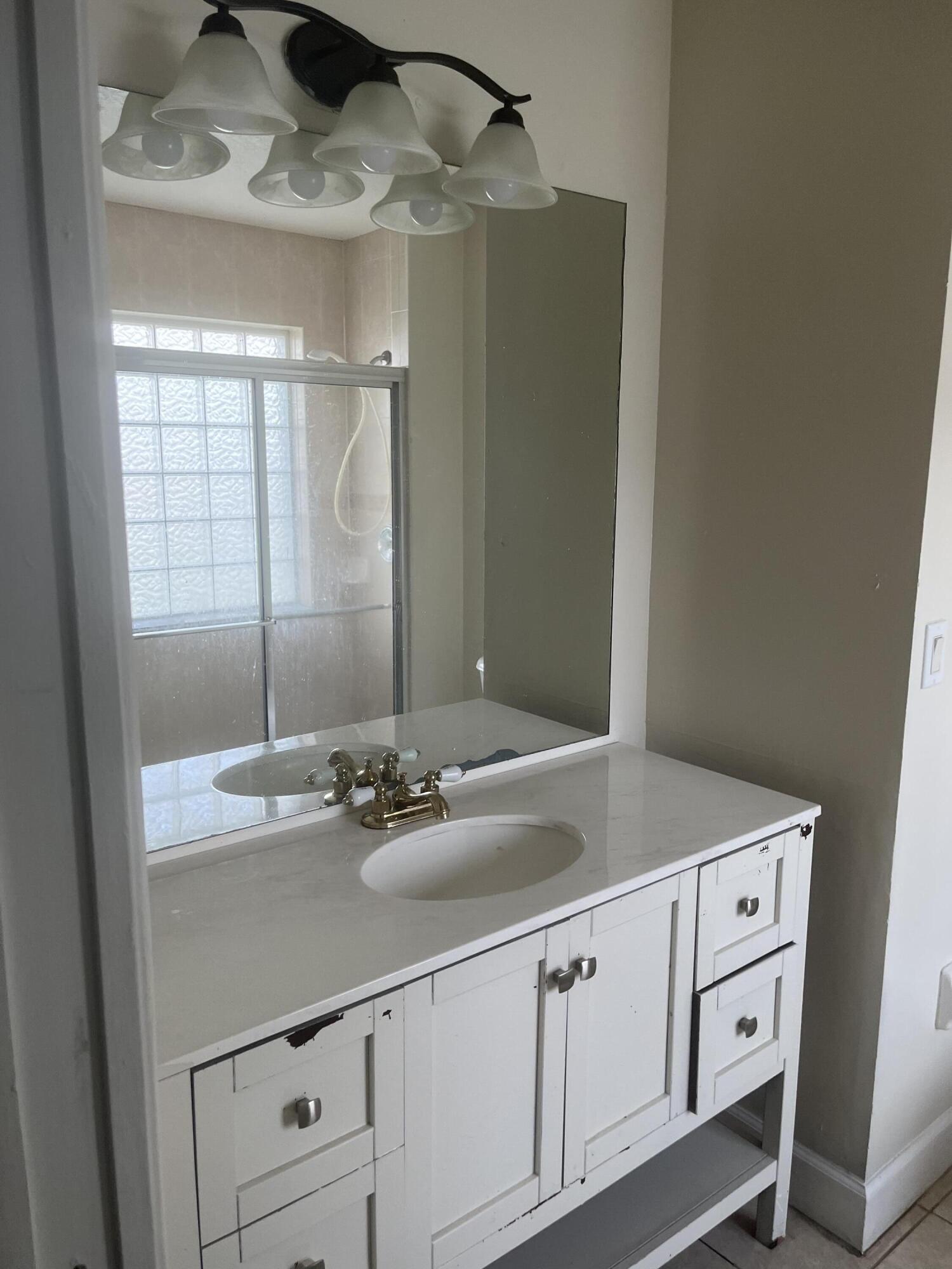 702 Southwest Amber Terrace Port St. Lucie, FL 34953 - Photo 9 of 16 a bathroom with a sink and a mirror