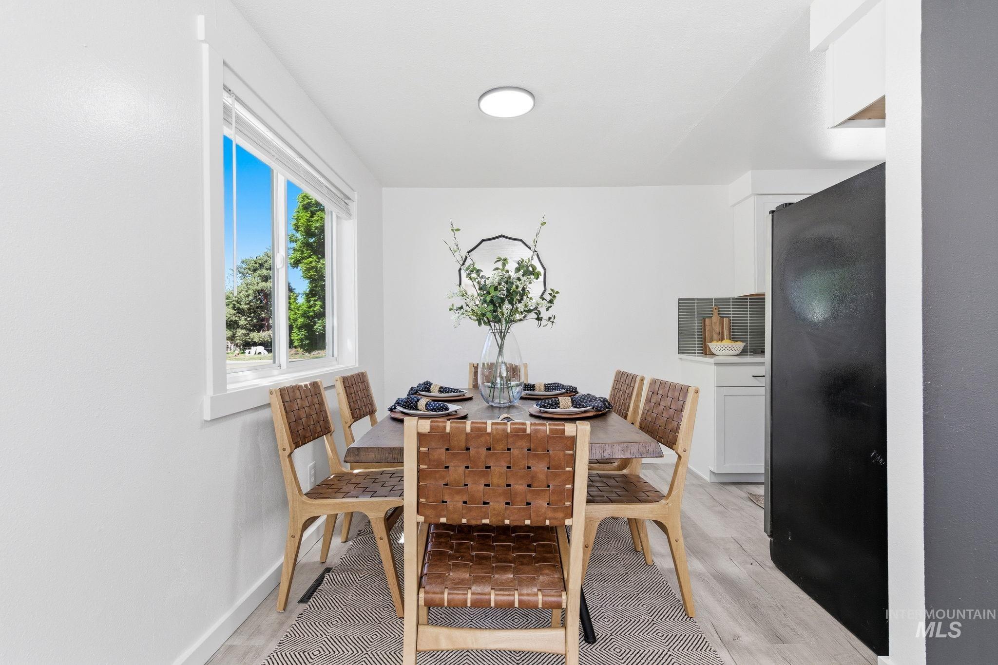 2224 Rachel Circle Boise, ID 83706 - Photo 21 of 50 Bright dining area featuring wood-finish flooring, a contemporary flush-mount ceiling light, and a large window
