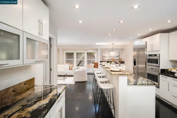 a large kitchen with lots of counter top space a sink appliances and cabinets