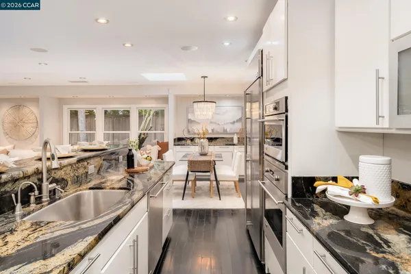 a kitchen with stainless steel appliances granite countertop a sink stove and refrigerator