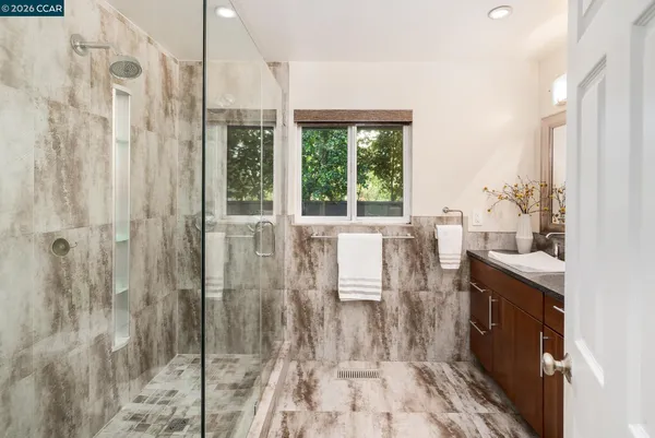 a bathroom with a sink a mirror and a shower