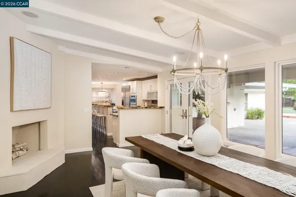 a dining room with wooden floor and chandelier