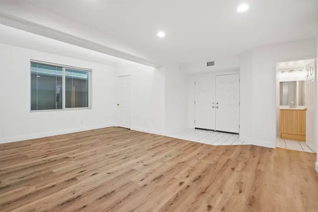 a view of empty room with wooden floor and entryway