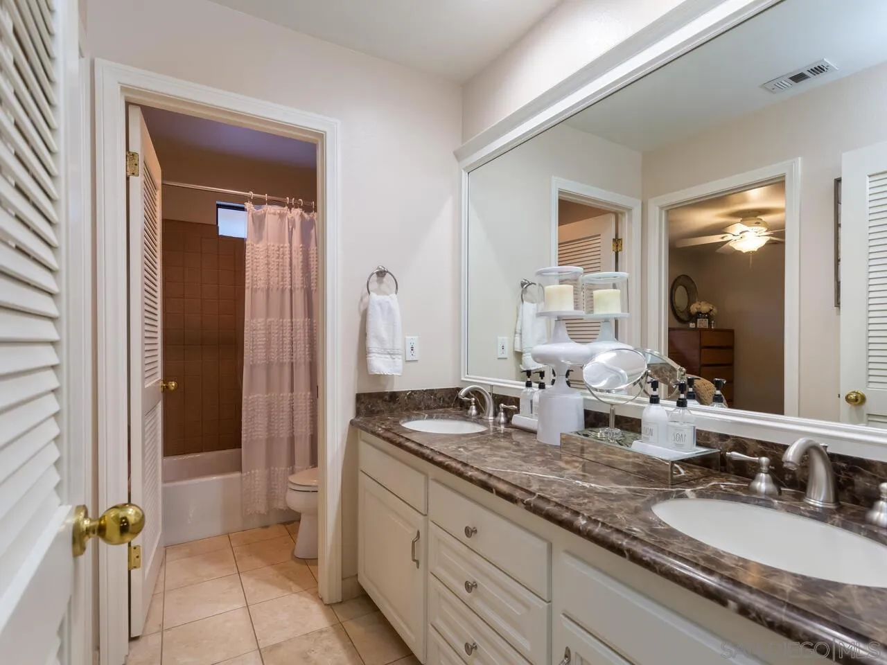 11630 Shadowglen Road El Cajon, CA 92020 - Photo 39 of 64 a bathroom with a granite countertop sink a mirror and a shower