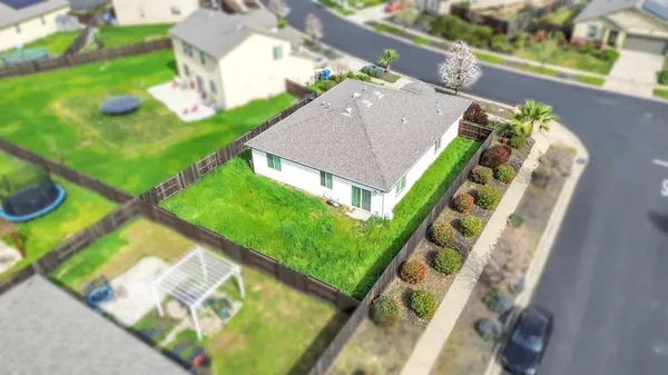 an aerial view of a house with a yard and potted plants