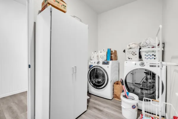 a kitchen with stainless steel appliances granite countertop a stove top oven a sink a dining table and chairs with wooden floor