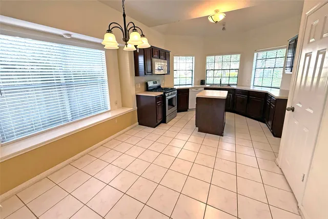 a kitchen with a sink a counter space cabinets and appliances