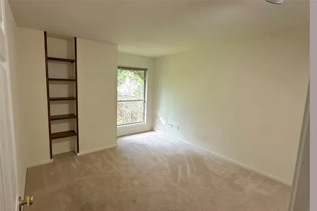 an empty room with windows closet and chandelier fan