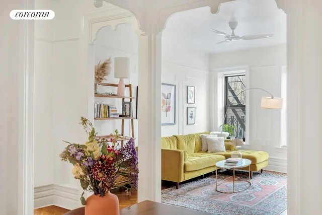 a living room with furniture flowerpot and a chandelier