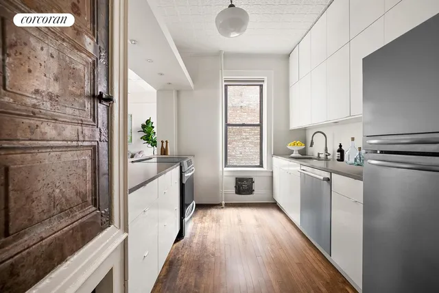a kitchen with sink a refrigerator and window