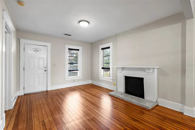 wooden floor fireplace and natural light in room