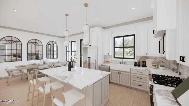 a large kitchen with stainless steel appliances a sink a table and chairs