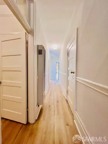 a view of a hallway with wooden floor and staircase
