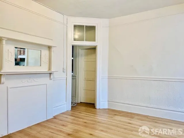 a view of an empty room with closet and mirror